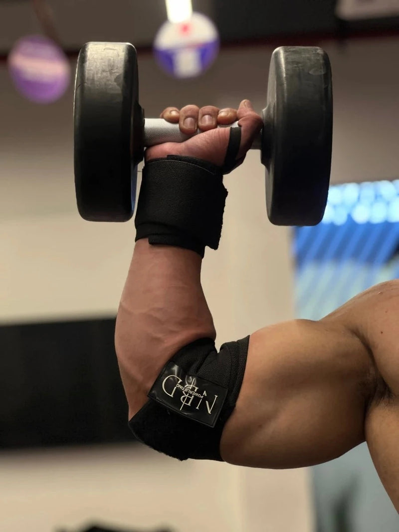 NBD Powerlifter wearing NBD Black Series elbow wraps during bench press training session