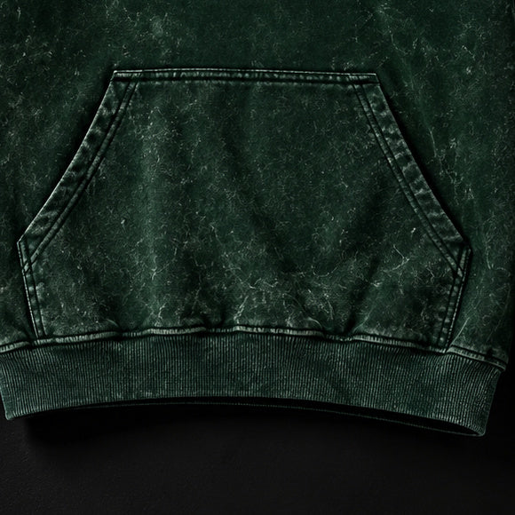 NBD IRON acid wash hoodie — kangaroo pocket and ribbed hem of the bottle green hoodie