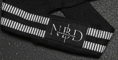 NBD lifting straps close-up: ribbed white rubber covering on the wrist band with the NBD Powerlifting logo