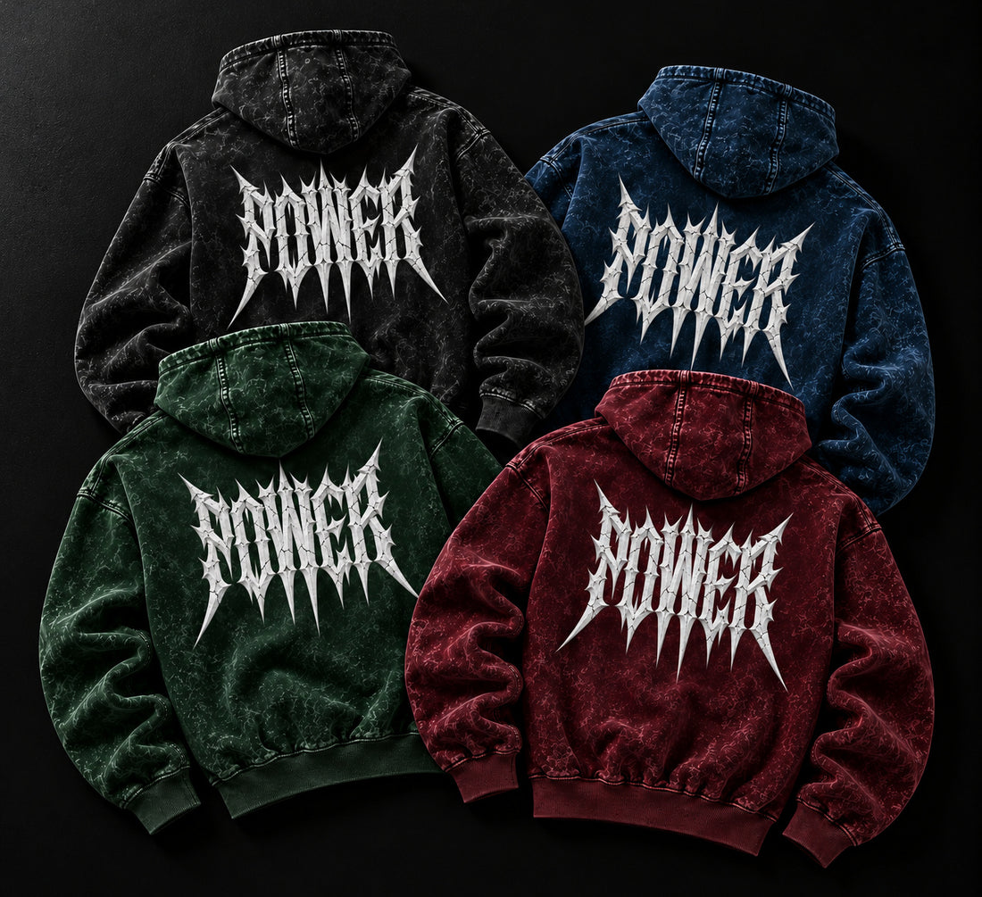 NBD POWER acid wash hoodies in all four colours laid together on a dark studio floor, print side up