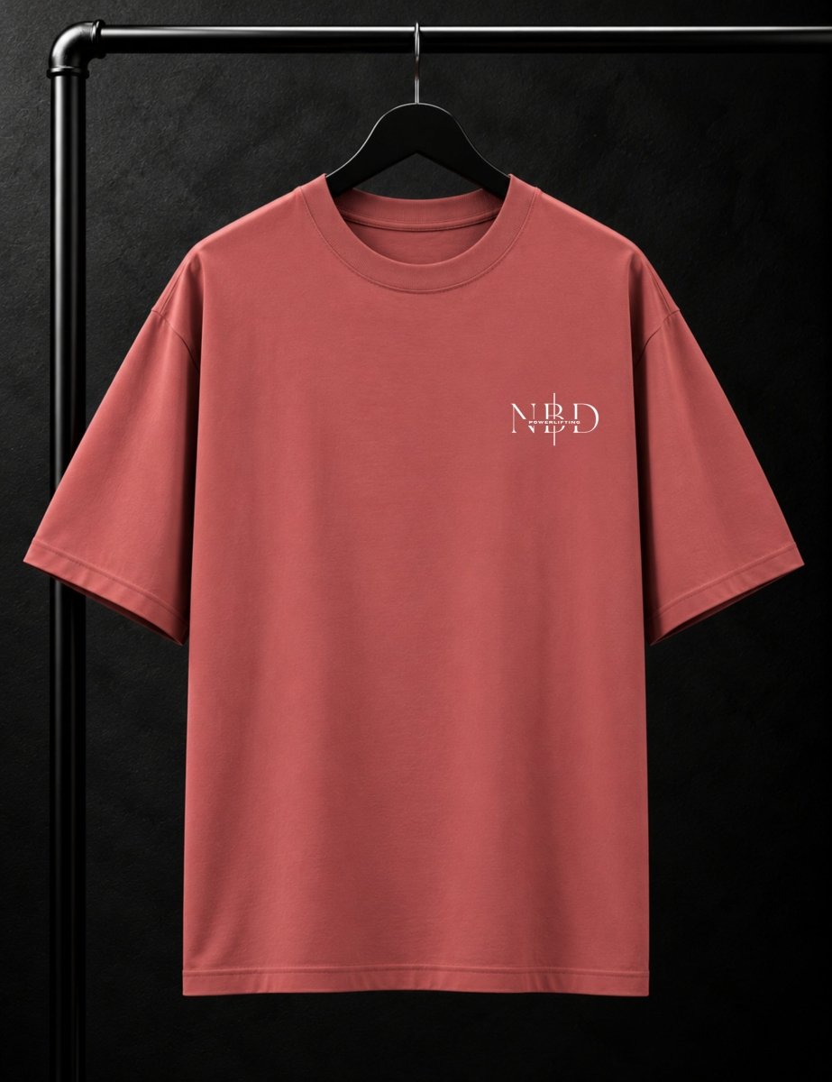 NBD POWERLIFTING Crest oversized T-shirt in Coral — front view, ribbed crew neck and small NBD Powerlifting mark on the left chest, studio shot on a hanger