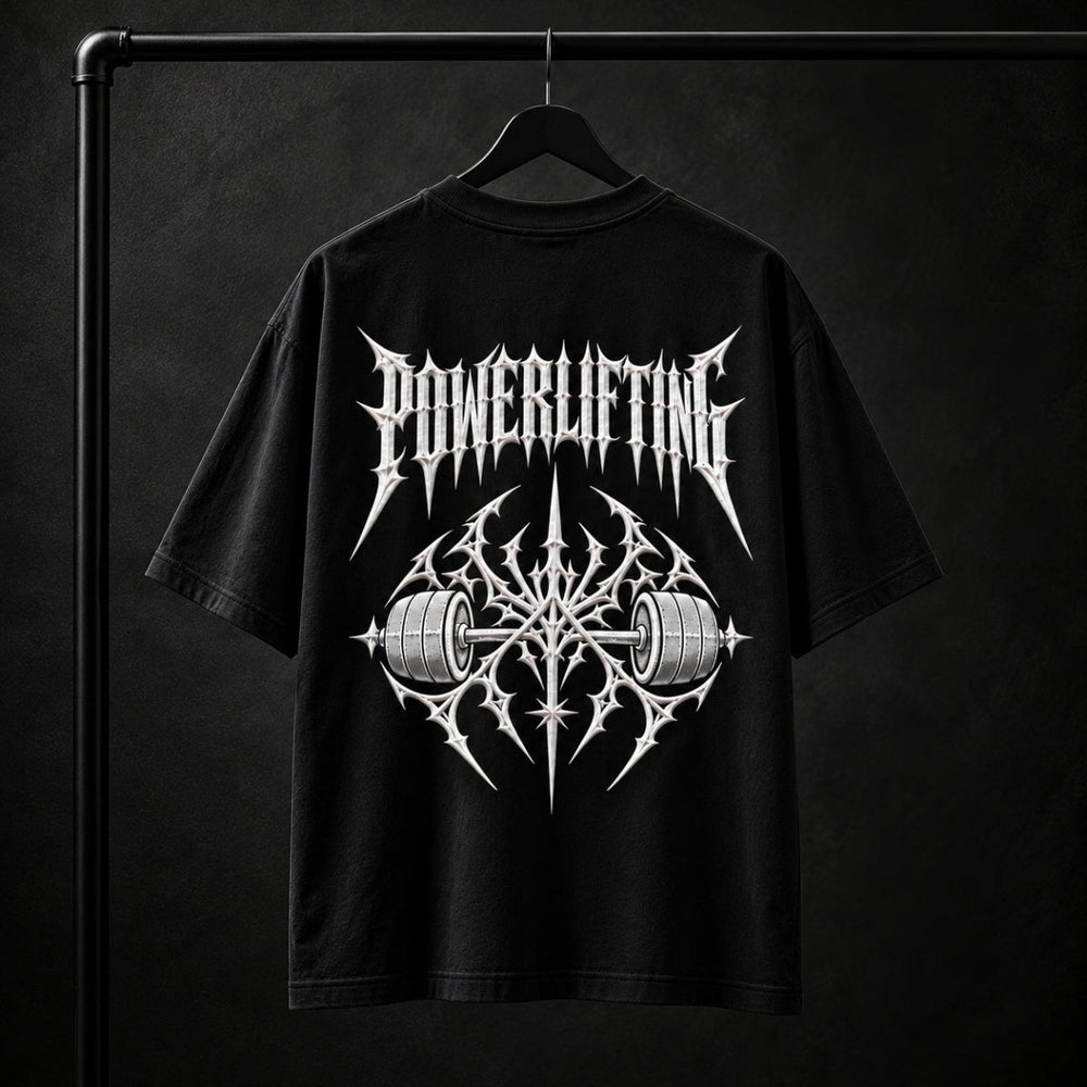 NBD POWERLIFTING Crest oversized T-shirt in Black — back view, raised white 3D puff print POWERLIFTING lettering above a barbell crest, studio shot on a hanger