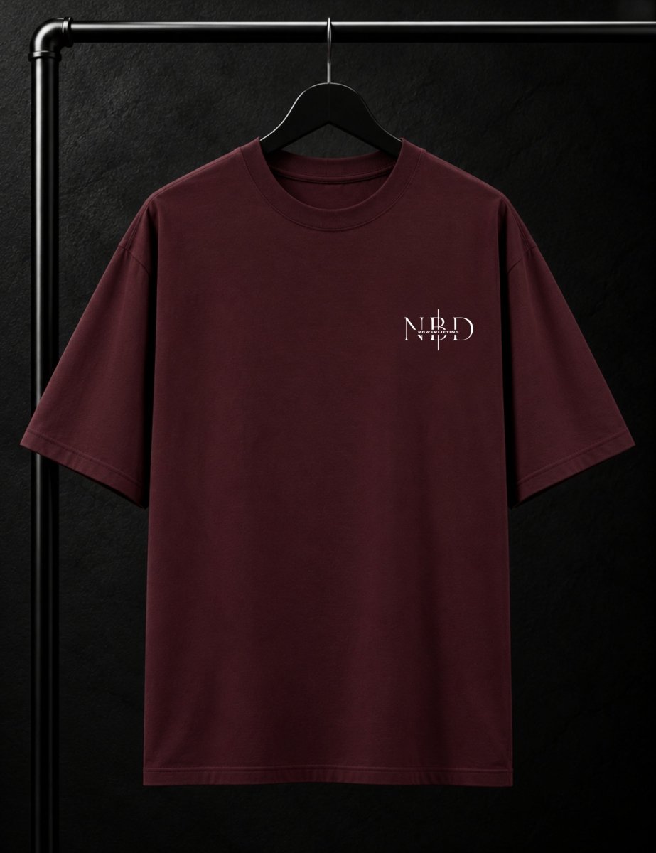 NBD POWERLIFTING Crest oversized T-shirt in Maroon — front view, ribbed crew neck and small NBD Powerlifting mark on the left chest, studio shot on a hanger