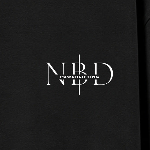 NBD POWERLIFTING Crest oversized T-shirt in Black — chest close-up, NBD Powerlifting mark on the left chest