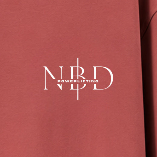 NBD POWERLIFTING Crest oversized T-shirt in Coral — chest close-up, NBD Powerlifting mark on the left chest