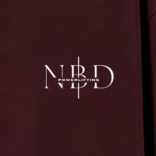 NBD POWERLIFTING Crest oversized T-shirt in Maroon — chest close-up, NBD Powerlifting mark on the left chest