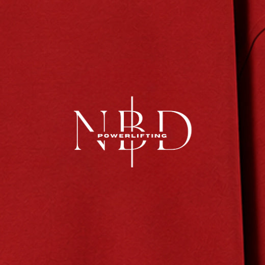 NBD POWERLIFTING Crest oversized T-shirt in Red — chest close-up, NBD Powerlifting mark on the left chest
