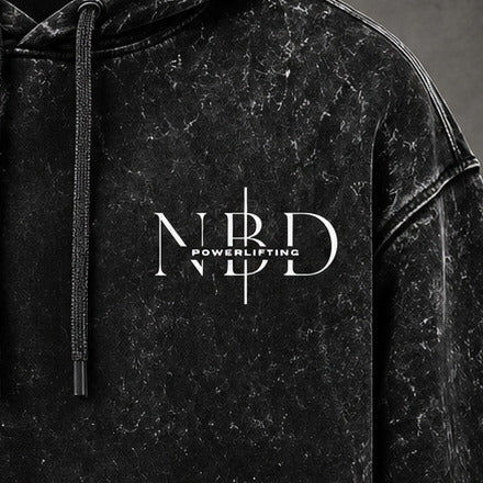NBD POWERLIFTING Crest hoodie — close-up of the NBD Powerlifting chest mark