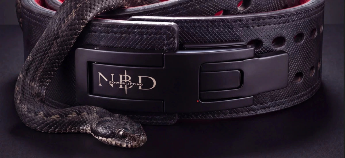 A viper coiled over the NBD Viper 13mm belt — matte black lever with the NBD monogram